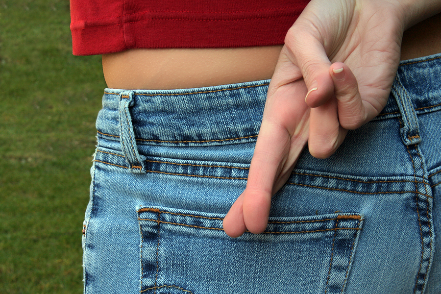 Woman's fingers crossed behind her back